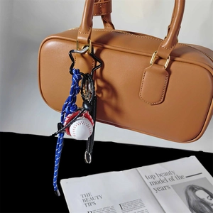 Portachiavi da baseball intrecciato blu con fibbia a stella su borsa in pelle marrone
