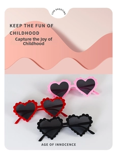 Detail of scalloped heart-shaped sunglasses for kids in pink, red, and black colors
