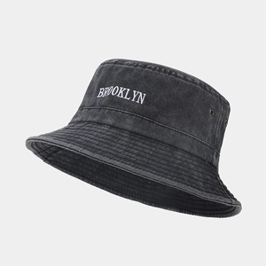 Détail de la broderie Brooklyn et œillets sur chapeau bob en denim noir délavé