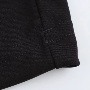 Close-up of the professional stitching and thick knitted fabric texture of the black dress
