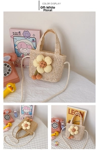 Detail view of straw woven cream kids crossbody bag with 3D yellow flower and cherry charms