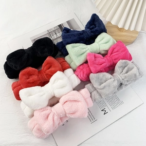 Coral fleece bow headbands in eight colors arranged on a white textured background