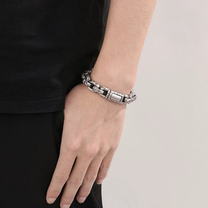Close-up of men's silver stainless steel chain bracelet with vintage hammer texture on wrist