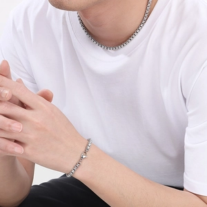 Detail of man wearing silver stainless steel link necklace and bracelet set