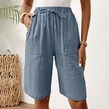 Detail of blue linen shorts featuring elastic drawstring waist and practical side pockets