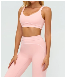 Close-up of pink yoga set showing white decorative stitching and matte texture