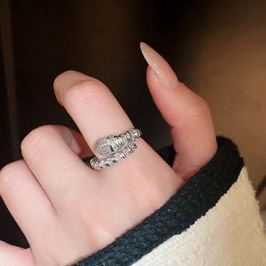 Close-up of a silver snake-shaped ring with cubic zirconia on a model's finger