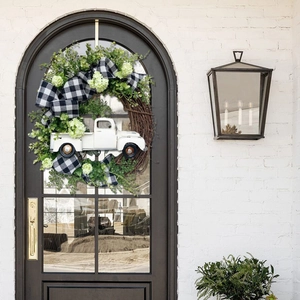 Christmas wreath with green leaves, buffalo plaid bow, and vintage white truck decor