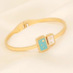 Detail of gold snake bangle featuring light blue and white enamel star pendants