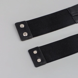 Close-up of black elastic belt featuring silver metal snap fastener and faux leather texture