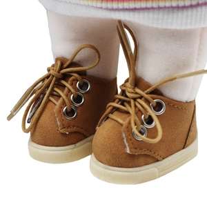Macro detail of brown doll boots with metal eyelets and textured white anti-slip soles