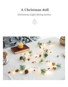 Detail of Christmas garland with pine cones, red berries and warm LED lights on soft fabric