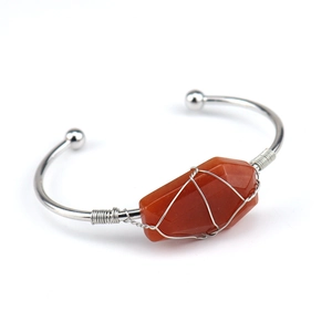 Macro detail of handmade silver copper wire wrapped bracelet with raw red agate stone