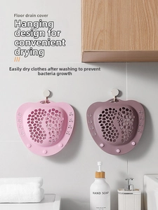 Close-up of pink and purple heart-shaped silicone floor drain covers with paw print holes