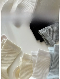 Détail de chaussettes multicolores à rayures verticales et bord élastique élargi