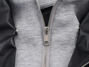 Close-up of metal zipper and grey knit fabric panels on a black leather effect jacket