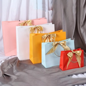 Colorful gift paper bags with champagne ribbon bows in various sizes and vibrant colors