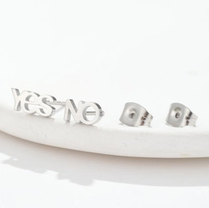 Detailed macro shot of silver stainless steel asymmetric Yes and No letter stud earrings