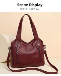 Detail of burgundy leather tote bag with lychee texture and dual vertical zipper pockets