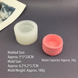 Detail view of rock textured silicone mold with a finished pink plaster candle vessel
