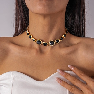 Close-up of vintage choker necklace with golden base and large round black gemstones