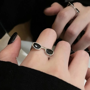Gros plan sur une bague Y2K en argent avec motif lunettes et émail noir