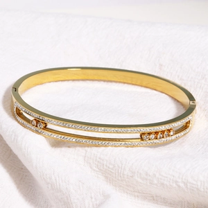 Détail d'un bracelet en acier titane doré avec cristaux mobiles en rails parallèles