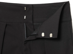 Detailed close-up of pleated waist with high-quality zipper and metal hook closure