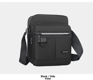 Detail of black oxford fabric messenger bag featuring multi-pocket zippers and metal D-ring