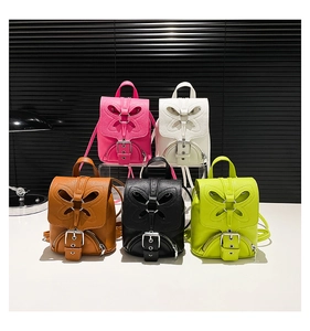 Détail de cinq mini sacs à dos en cuir avec découpe papillon en plusieurs couleurs vives