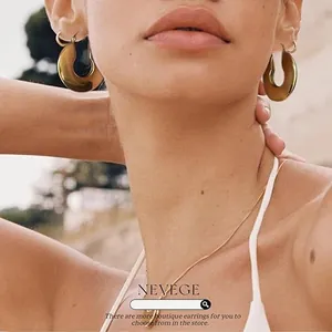 Vue rapprochée de boucles d'oreilles en forme de U plaquées or 18k sur un modèle