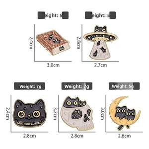 Set of five cat enamel pins with book and UFO designs in black and gold metal