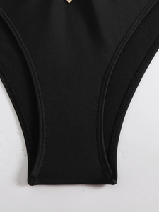 Detailed macro view of black ribbed bikini fabric with golden metal diamond ornament