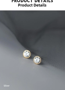 Close-up of golden S925 silver round stud earrings featuring sparkling clear cubic zirconia