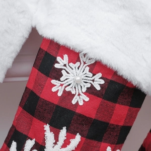 Close-up of red and black buffalo plaid Christmas stocking with plush cuff and snowflake