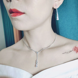 Close-up of elegant silver wedding jewelry set with rhinestone necklace and earrings