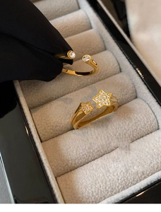 Detailed view of gold plated star rings with sparkling zircon stones in a jewelry box