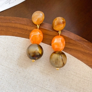 Three-tier acrylic marble tassel earrings with geometric circular resin drops in warm amber