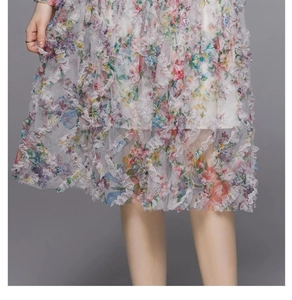 Detalle del dobladillo de volantes escalonados y estampado floral en vestido de gasa
