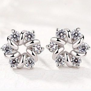 Macro shot of silver flower stud earrings with sparkling cubic zirconia petal inlay