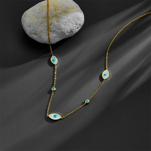 18K gold plated stainless steel necklace featuring evil eye pendants on grey fabric