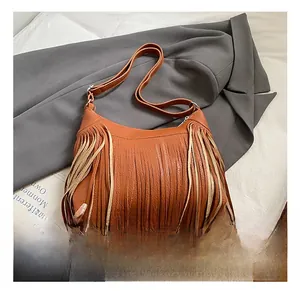 Detail of a brown leather shoulder bag with two-tone fringe tassels and top zipper