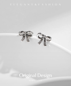 Detailed macro view of silver bow earrings with sparkling pavé cubic zirconia inlay
