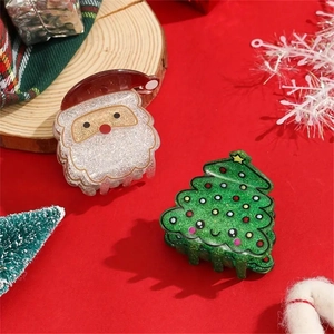Close-up of glittery Santa Claus and Christmas tree hair claws on a festive red background