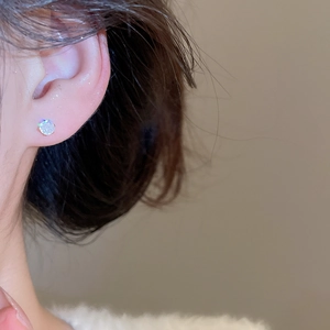 Close-up of a sparkling zircon stud earring on model for luxury jewelry set