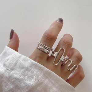 Close-up of minimalist 925 sterling silver rings with geometric textures on hand