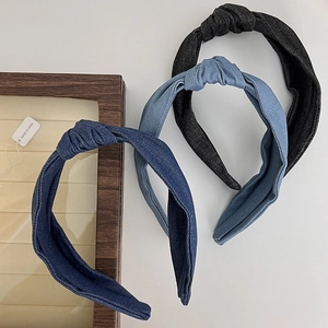 Detailed view of denim knotted headbands in dark blue, medium blue, and black colors
