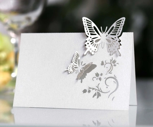 Detail of laser-cut butterfly place card with a pearlescent white finish for weddings