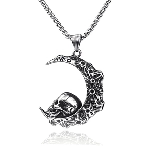 Vue détaillée du pendentif croissant de lune et crâne sur chaîne maille miroir
