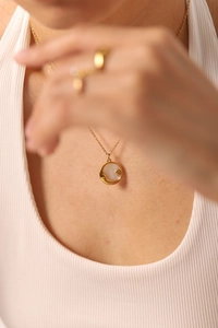 Détail du collier pendentif soleil et lune plaqué or 18k porté par un mannequin